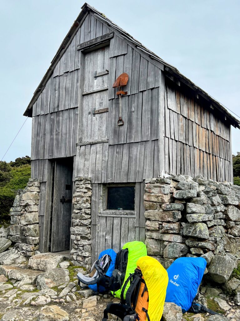 hiking-packs-at-old-mountain-hut Hiking packs resting outside an old mountain hut on Tasmania's Cradle Mountain walk