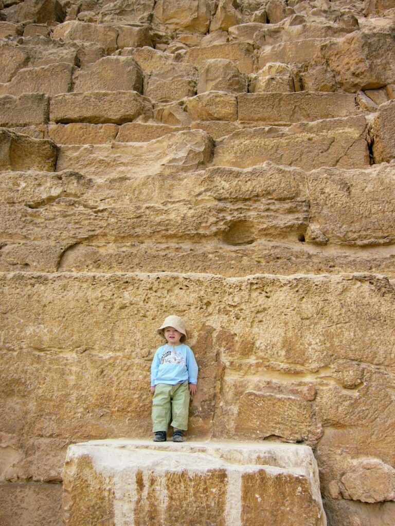 CHild-at-Cheops-pyramid CHild standing on the Cheops pyramid in Egpyt showing the scale and size of the blocks comprising the great pyramids