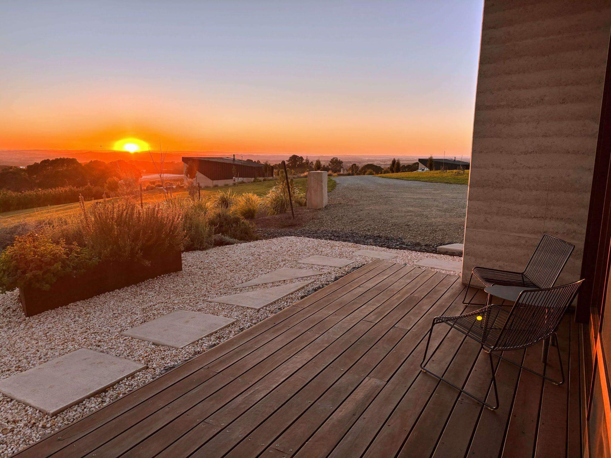 Panoramic sunset view from Mount Canobolas Summit Lookout showing rolling hills, vineyards, and the town of Orange NSW spread across the valley below with golden hour lighting