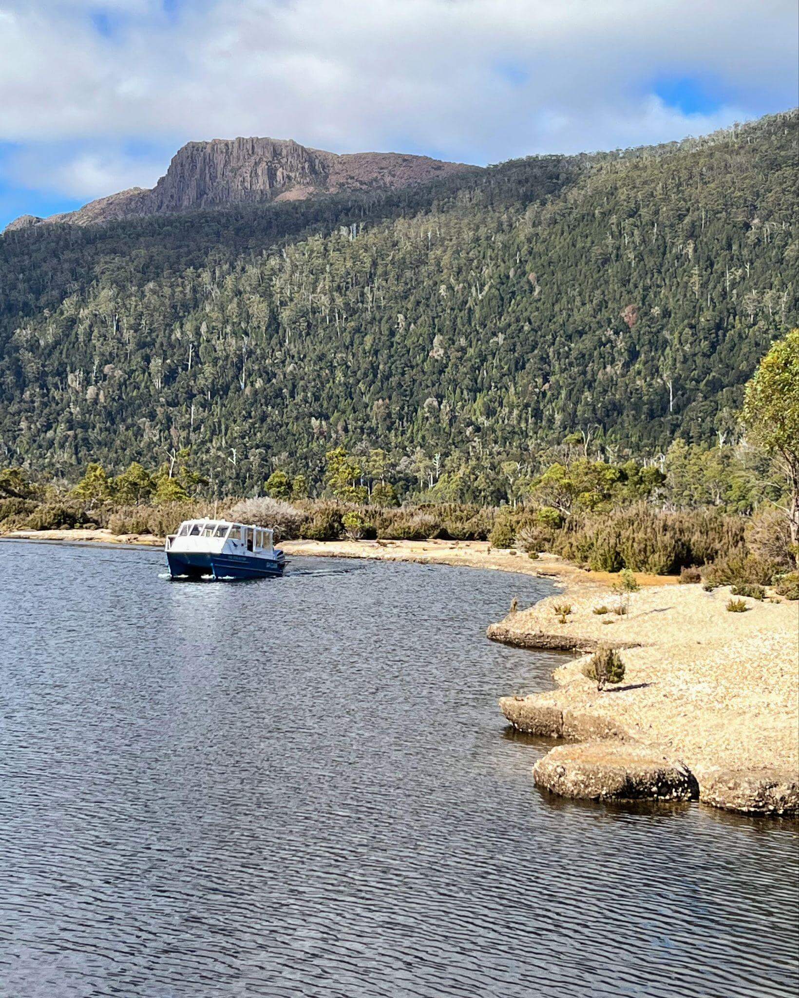 Ferry on Lake St Clair with mountains in background and hikers ready to board